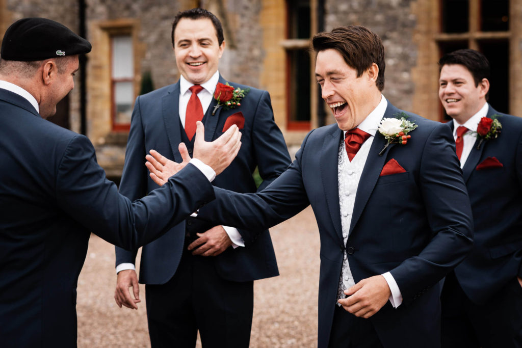 Groom greets groomsmen at Huntsham Court