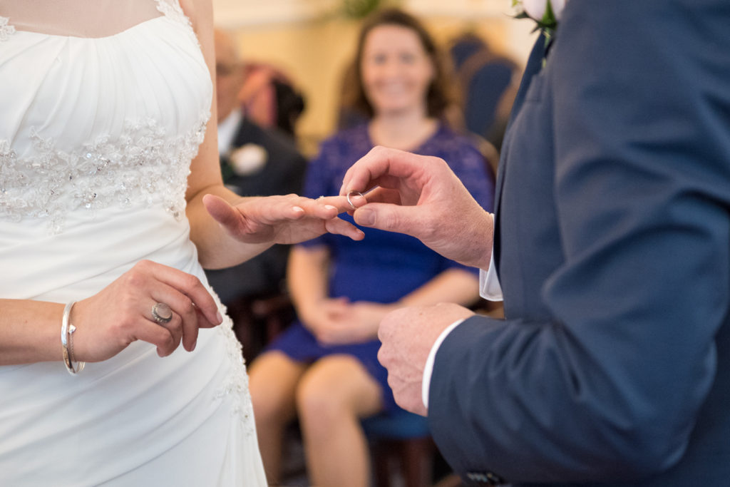 groom places ring on finger
