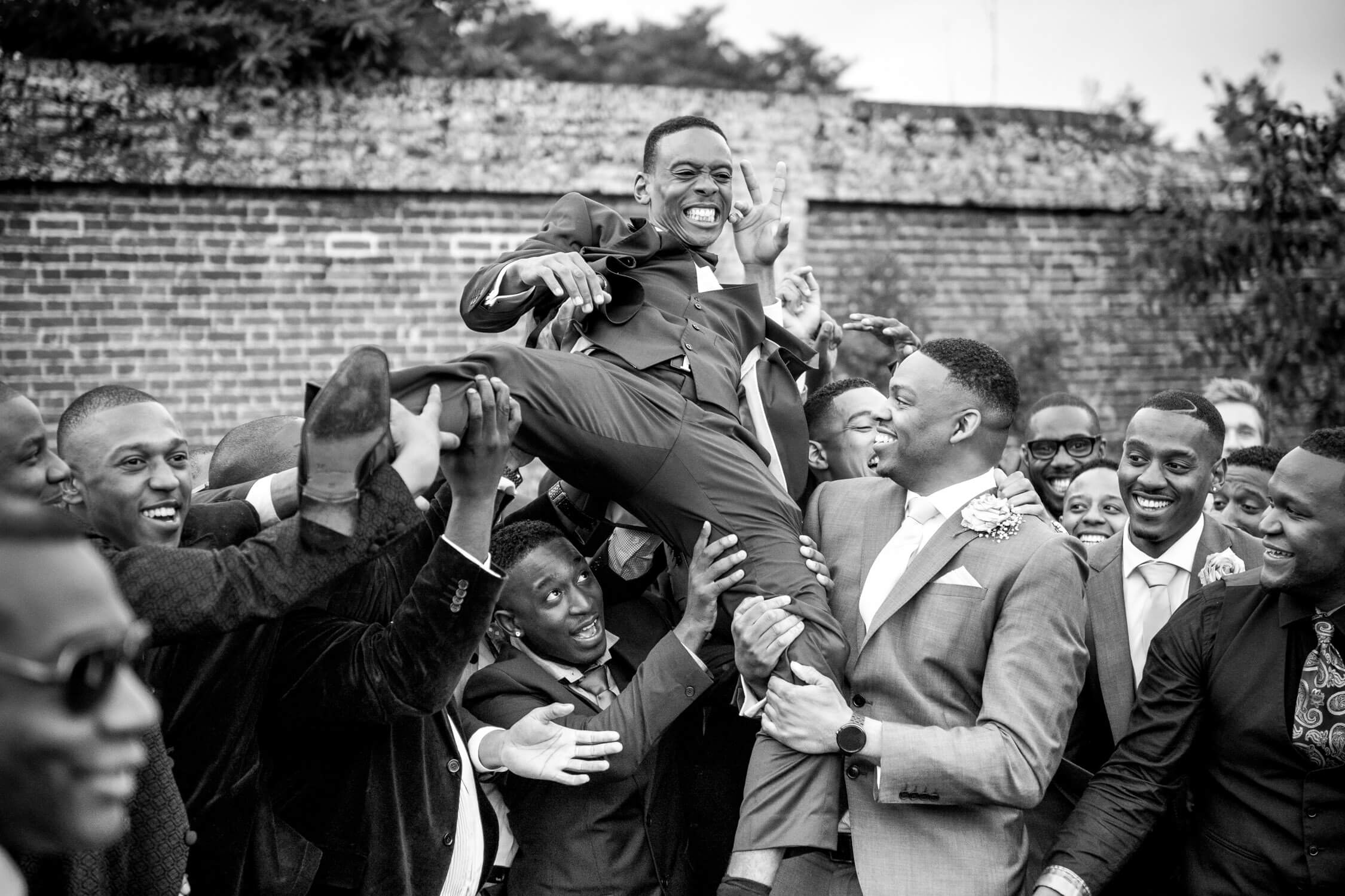 Groom being lifted in the air