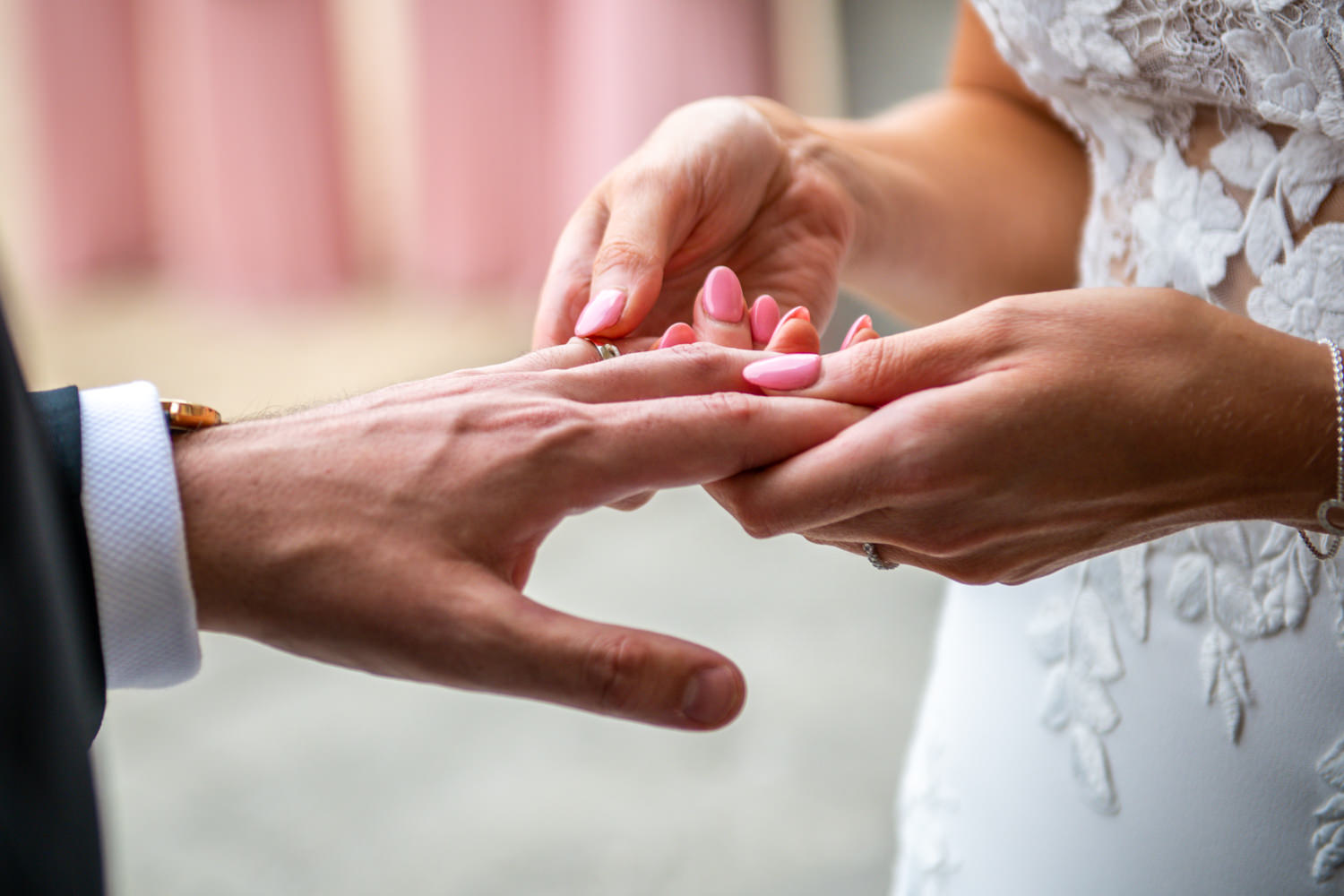 brideg places ring on grooms finger at Stoke Park Wedding